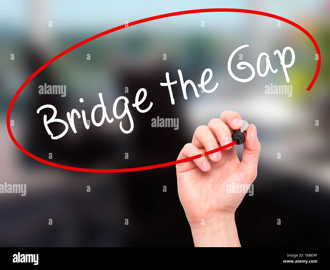 Man Hand writing Bridge the Gap with black marker on visual screen Stock Photo