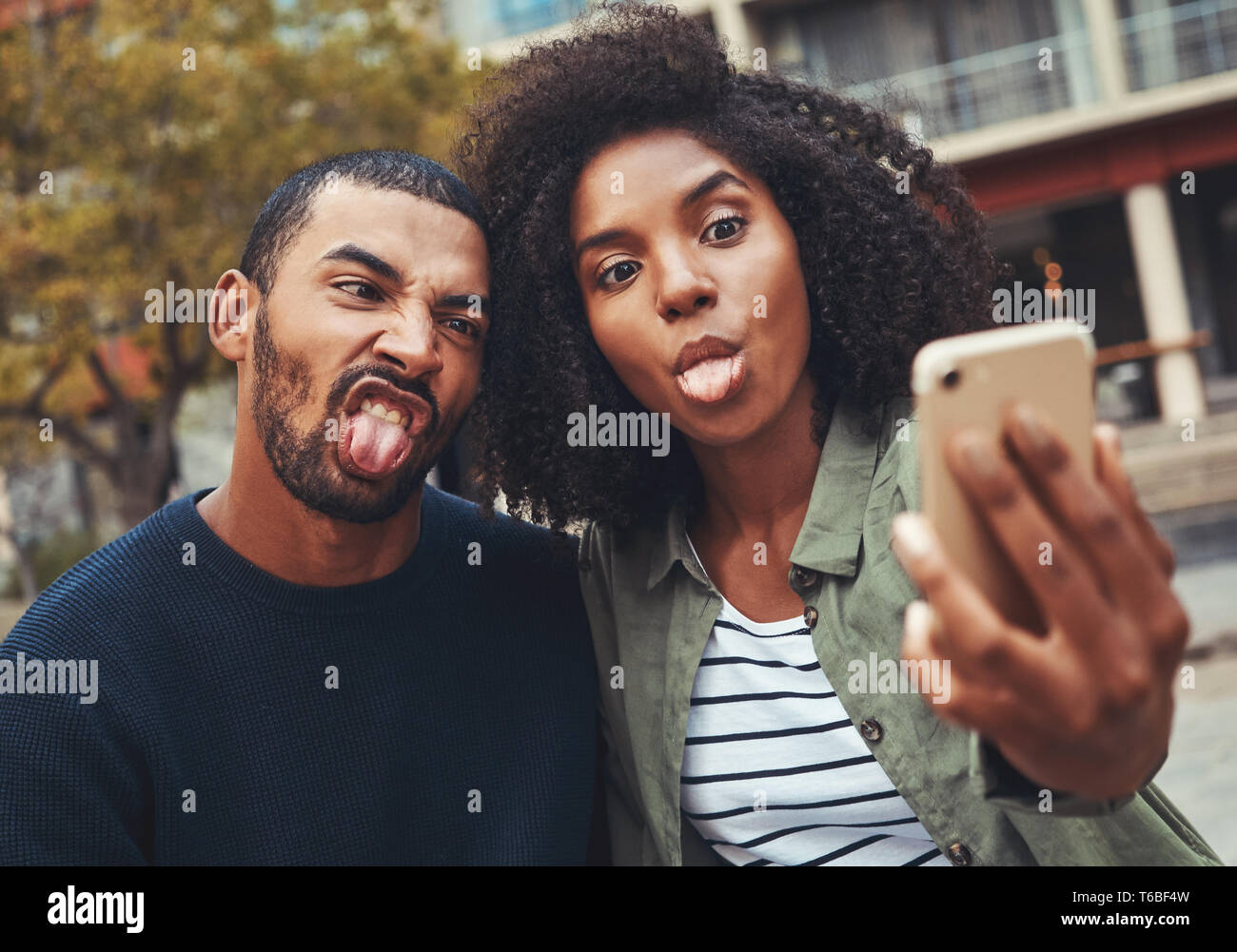 Young couple making funny face while taking selfie on smart phone Stock Photo