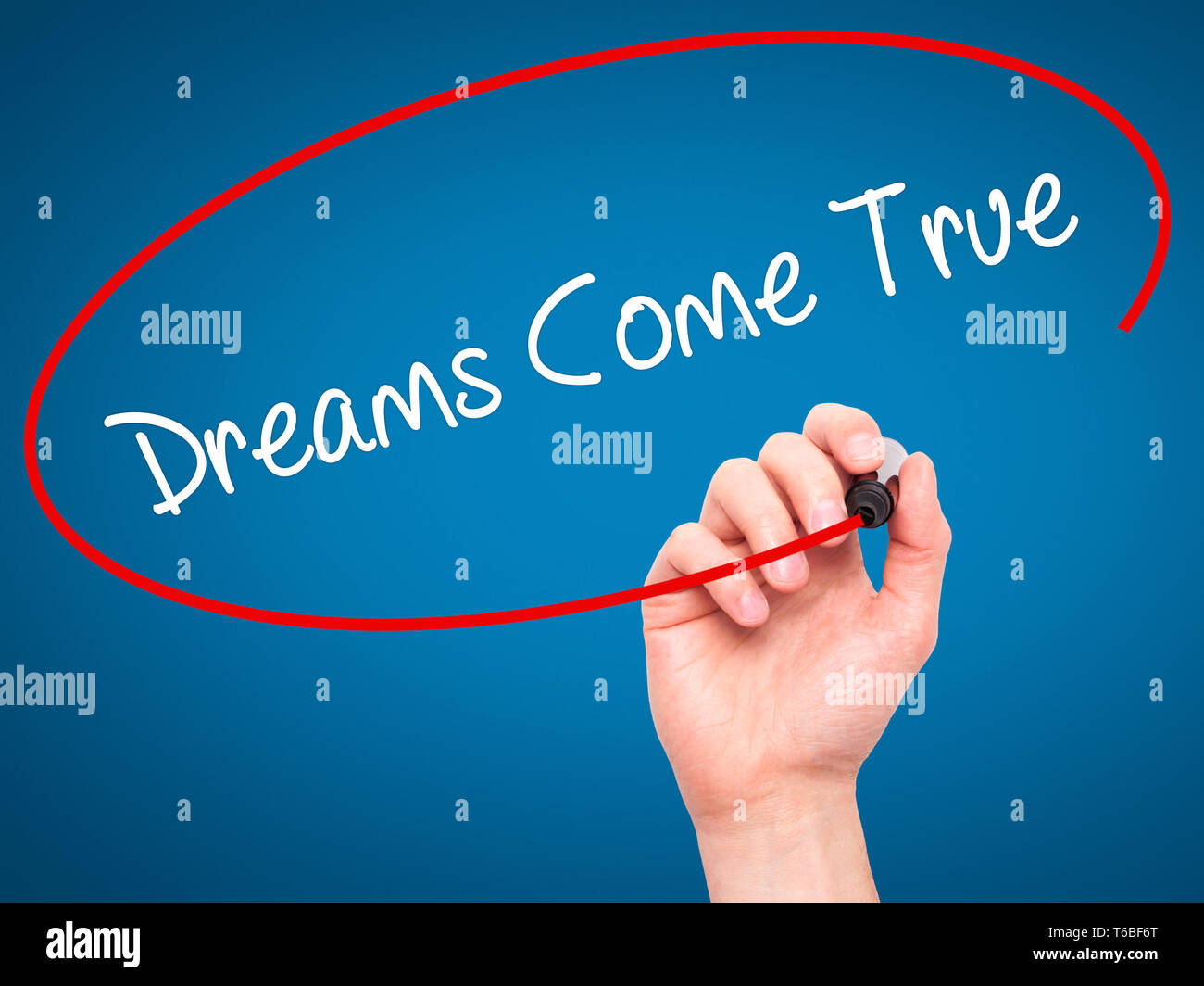 Man Hand writing Dreams Come True with black marker on visual screen Stock Photo