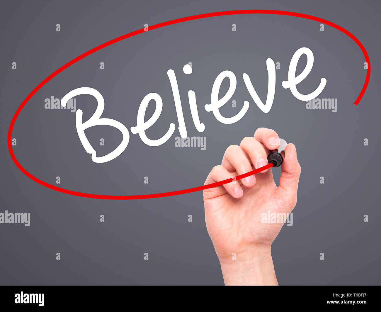 Man Hand writing Believe with black marker on visual screen Stock Photo