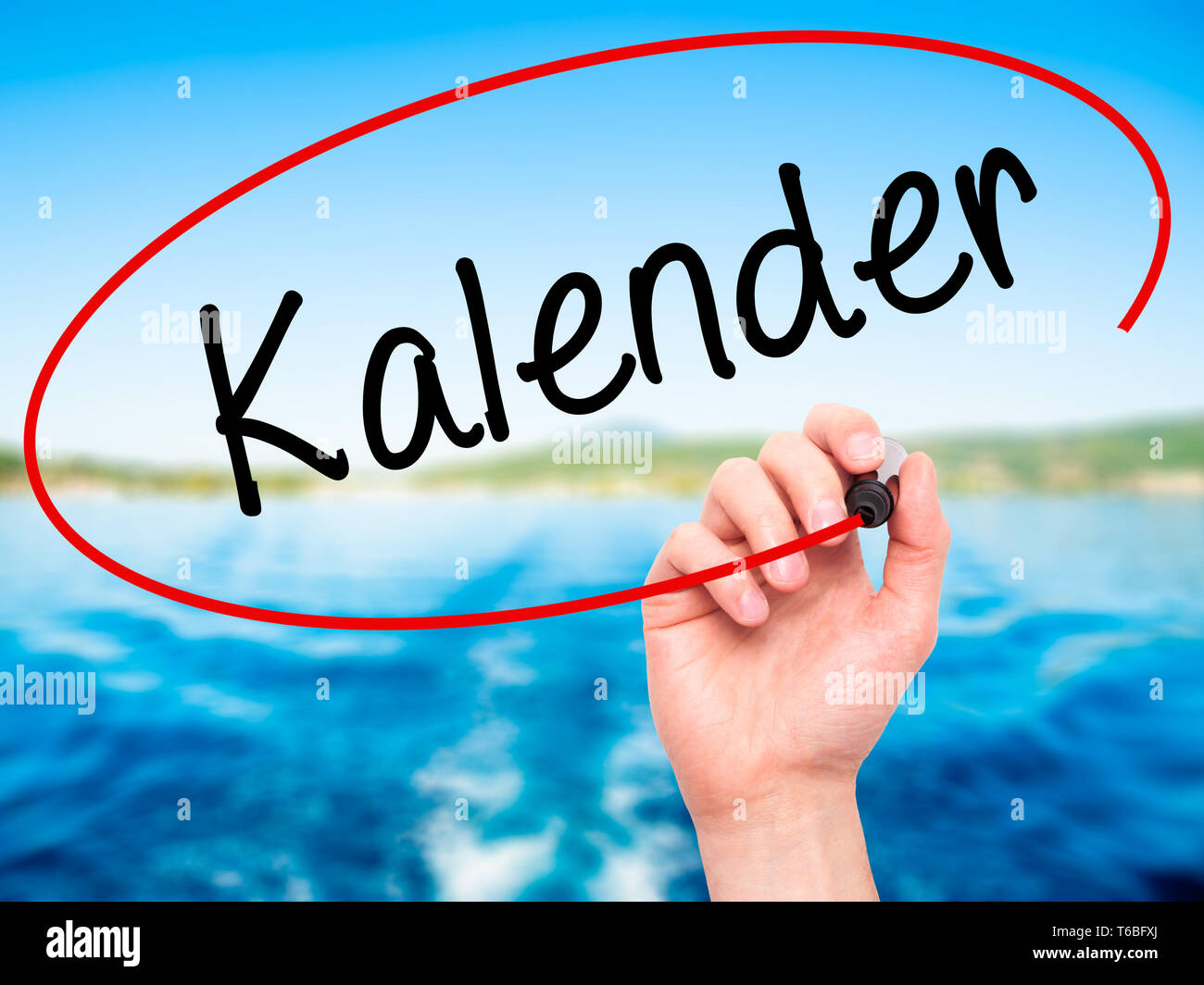 Man Hand writing Kalender (Calendar in German) with black marker on