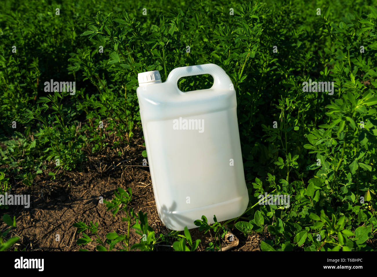 Pesticide jug mock up in clover field, crop protection concept Stock Photo