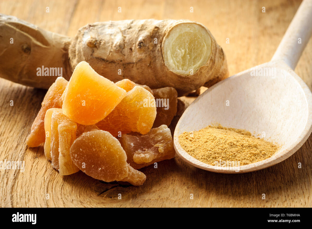 Three kinds of ginger ground spice fresh and candied on rustic table