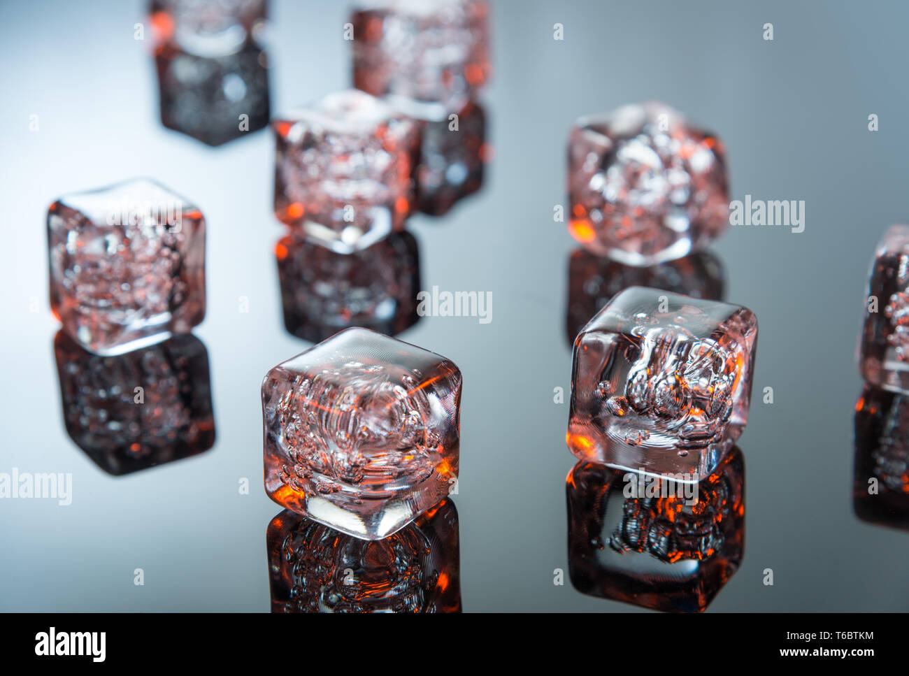 Glowing ice cubes on reflective surface Stock Photo