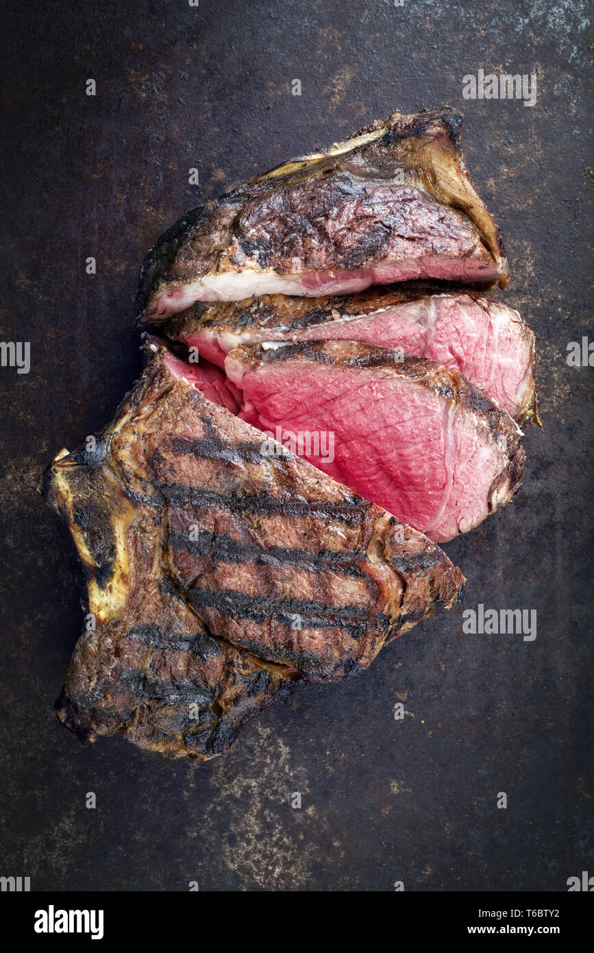 Barbecue dry aged Rib of Beef as closeup on a rusty metal sheet Stock