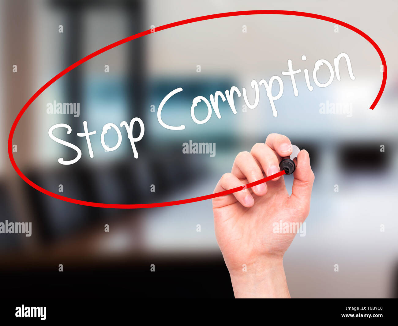 Man Hand writing Stop Corruption with black marker on visual screen. Stock Photo