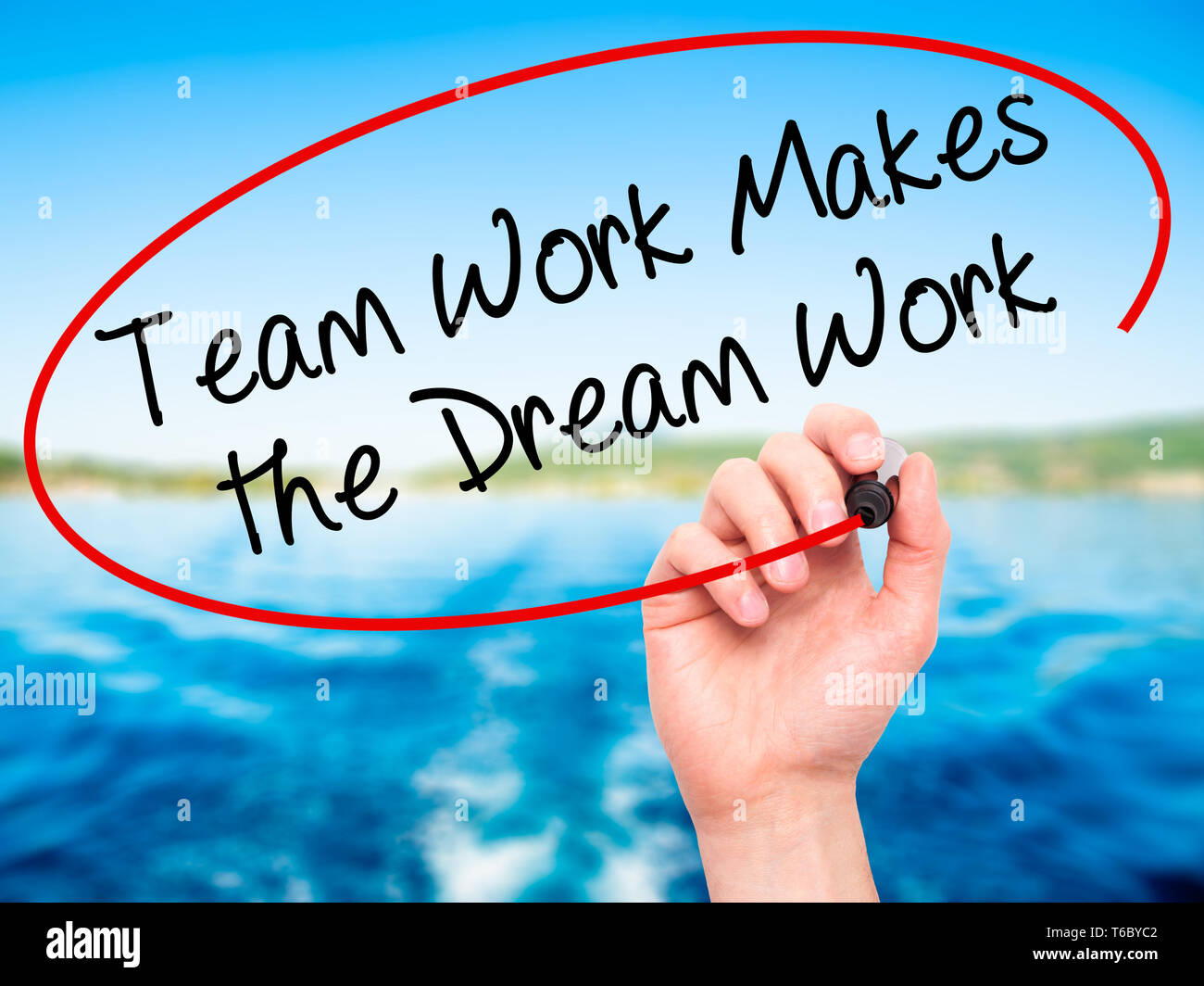Man Hand writing Team Work Makes the Dream Work with black marker on visual screen Stock Photo