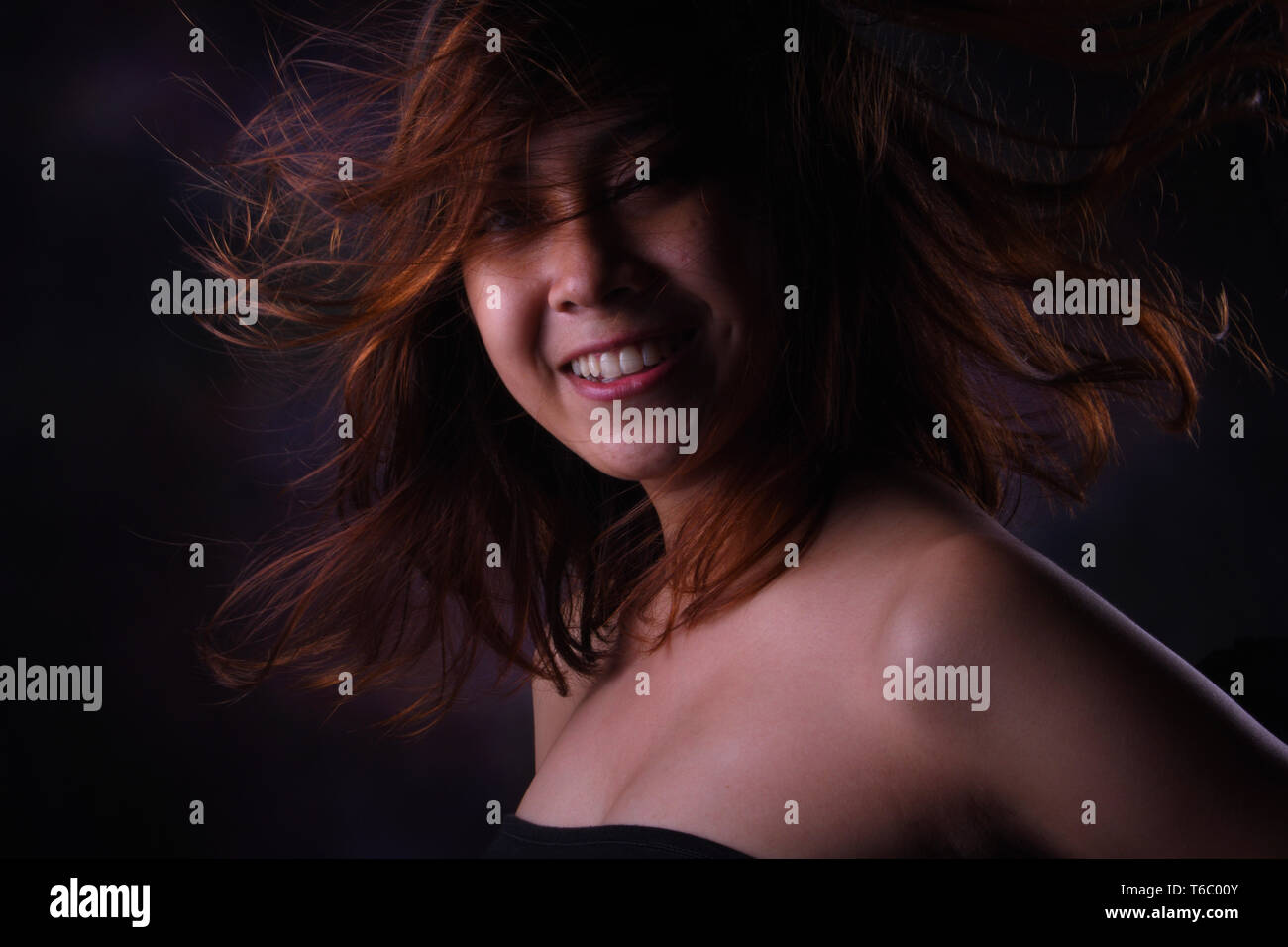 Smilling Woman Blonde Hair With Low Light Studio Stock Photo