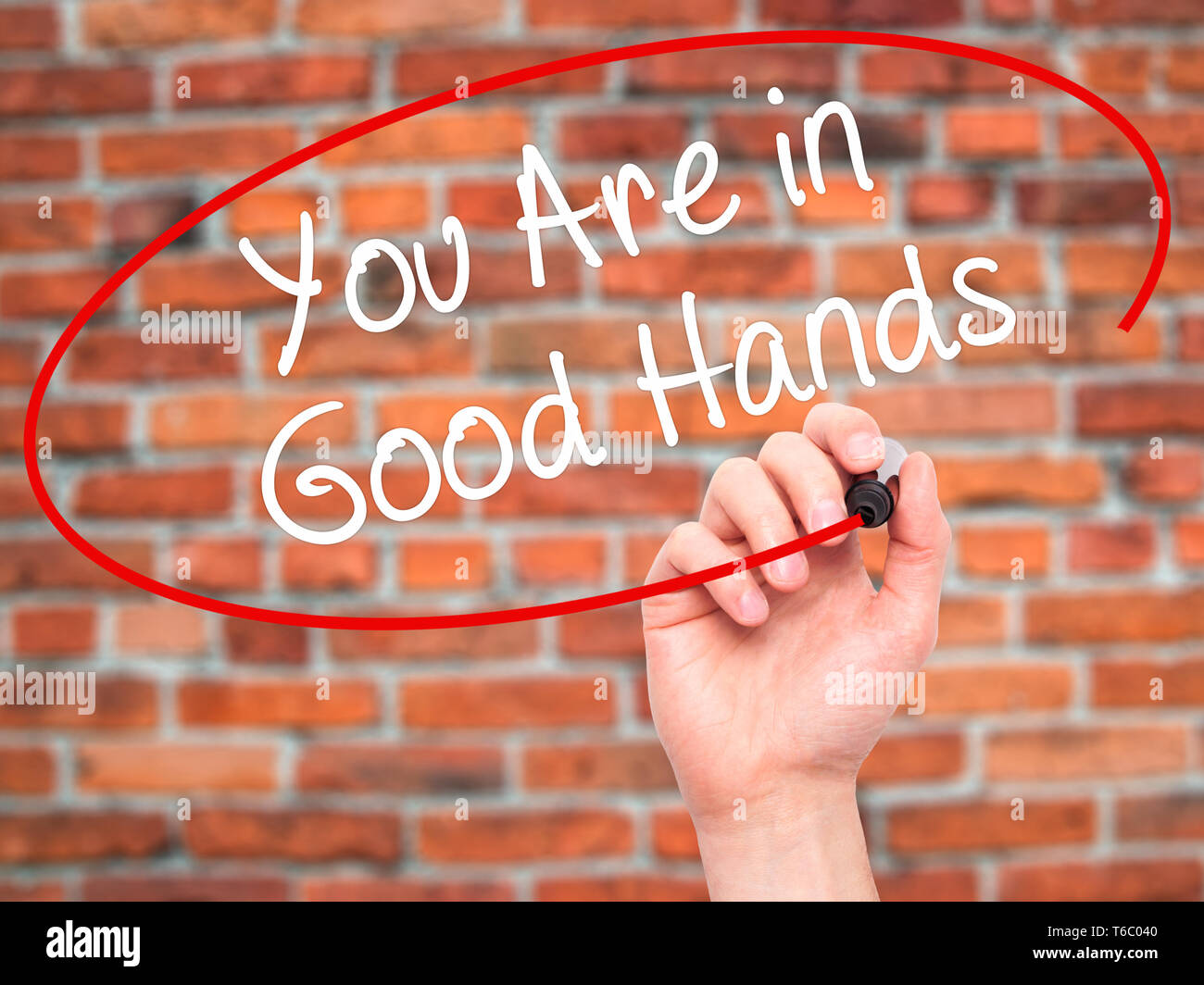Man Hand writing You Are in Good Hands with black marker on visual screen Stock Photo