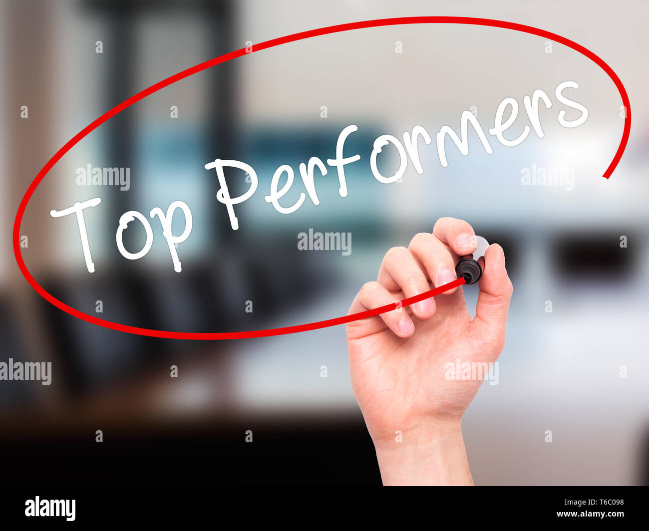 Man Hand writing Top Performers with black marker on visual screen Stock Photo
