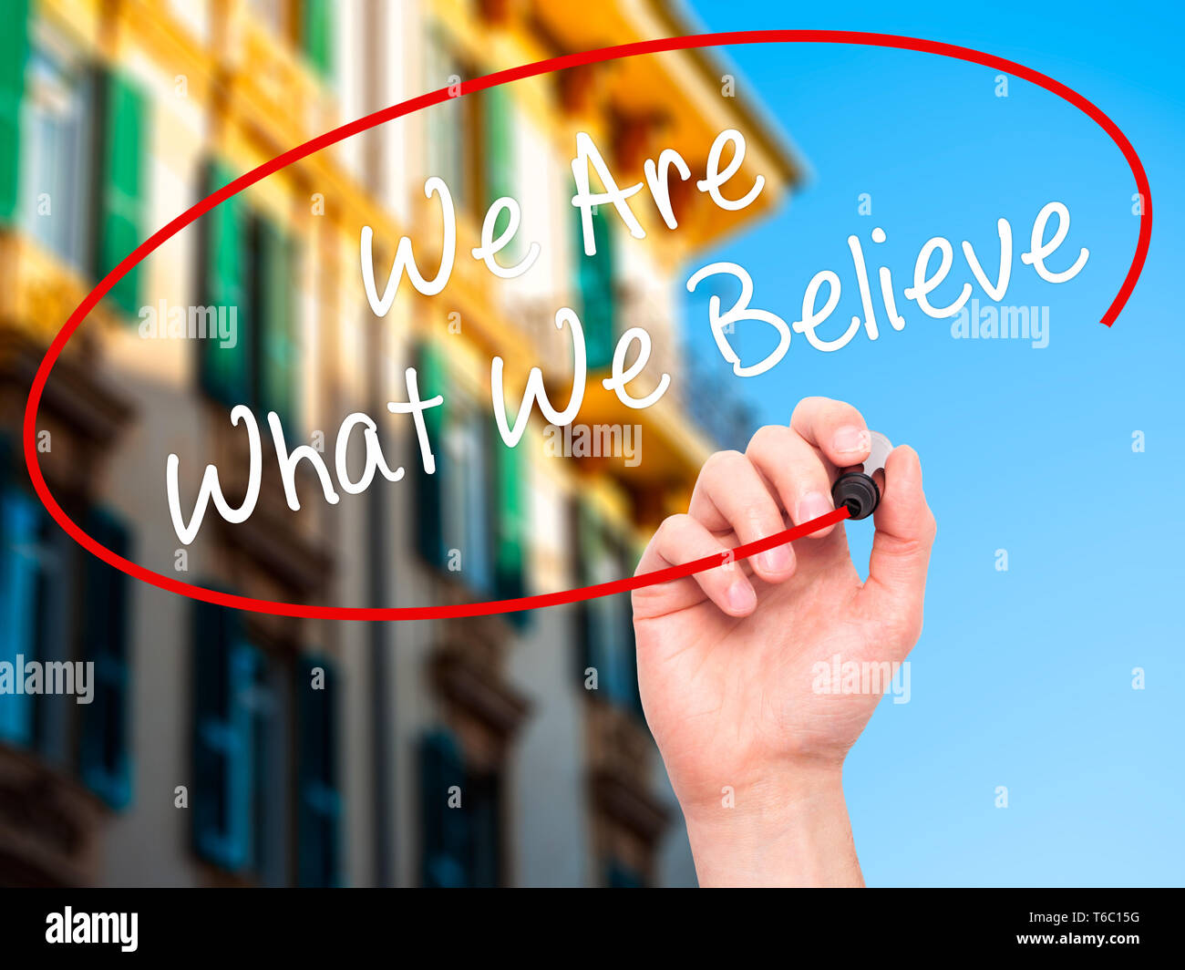 Man Hand writing We Are What We Believe with black marker on visual screen Stock Photo