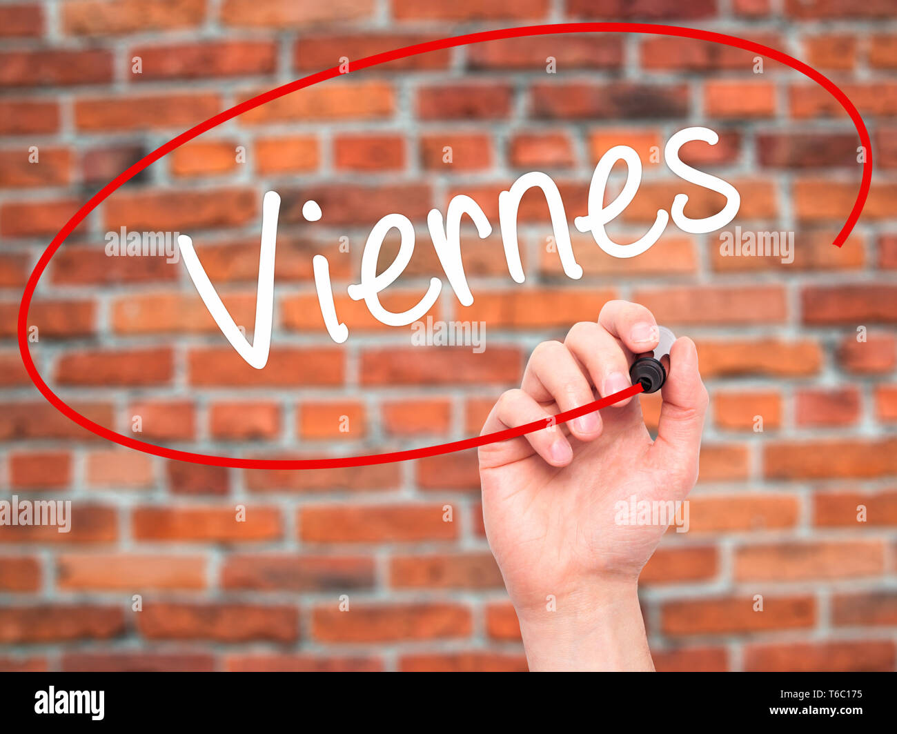 Man Hand writing Viernes (Friday in Spanish) with black marker on visual screen Stock Photo