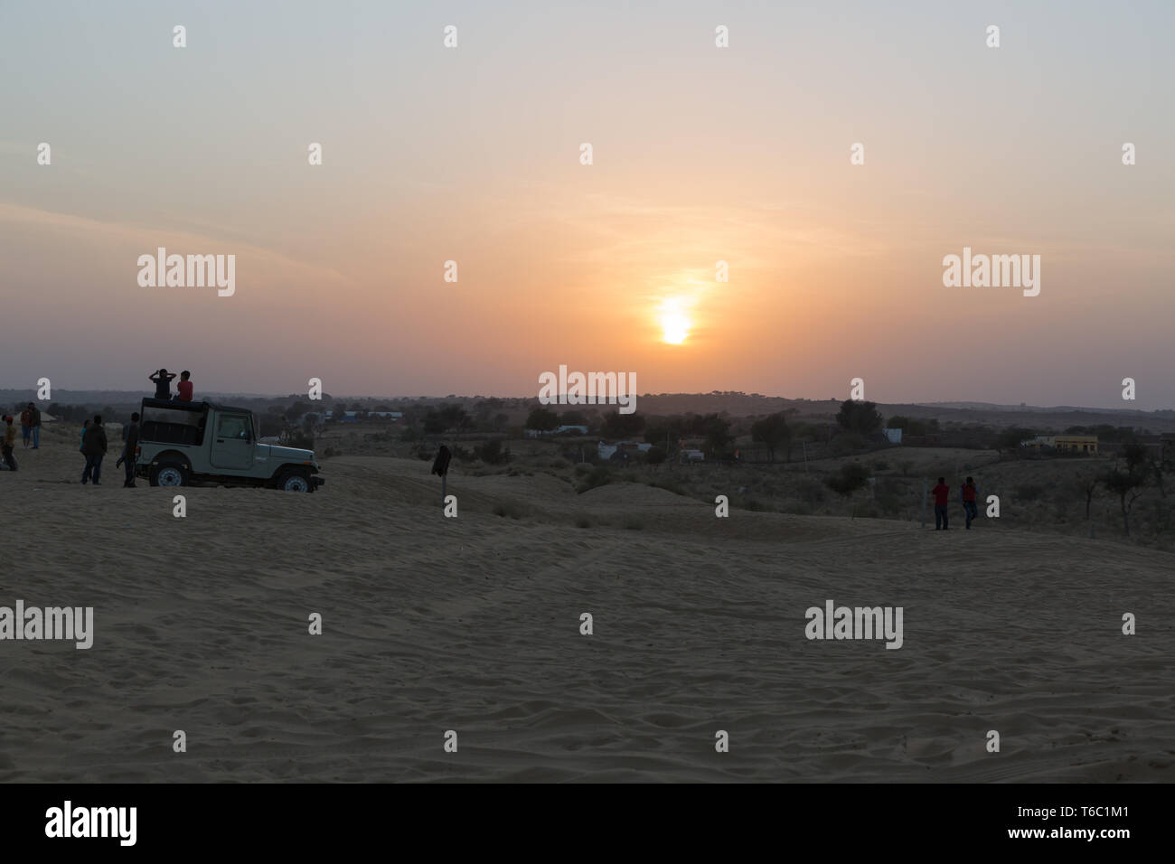 Desert Sunset with peaople silhouette and jeep in Rajasthan India Stock Photo