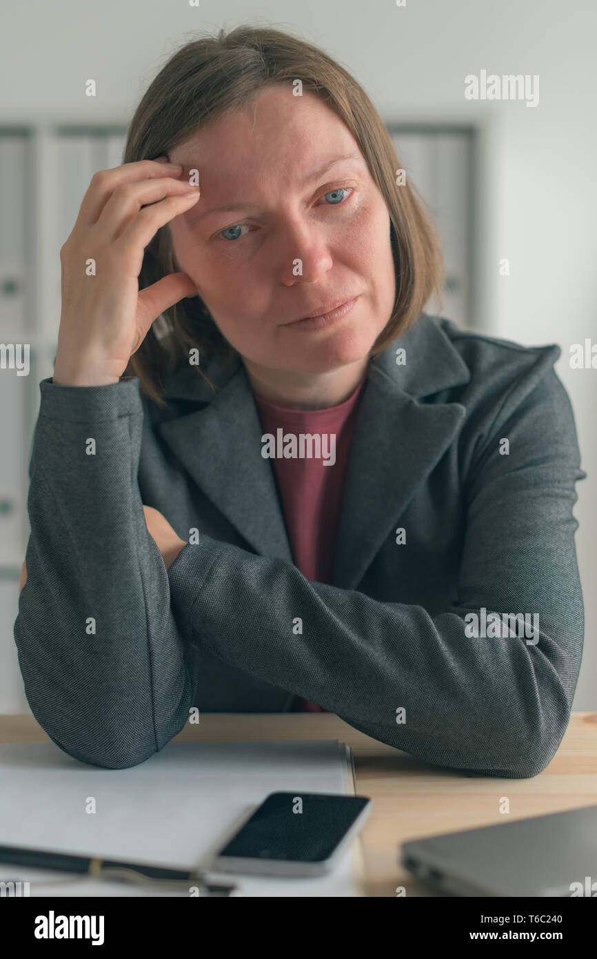 Businesswoman crying in office, portrait of sad female business person with tears in her eyes Stock Photo