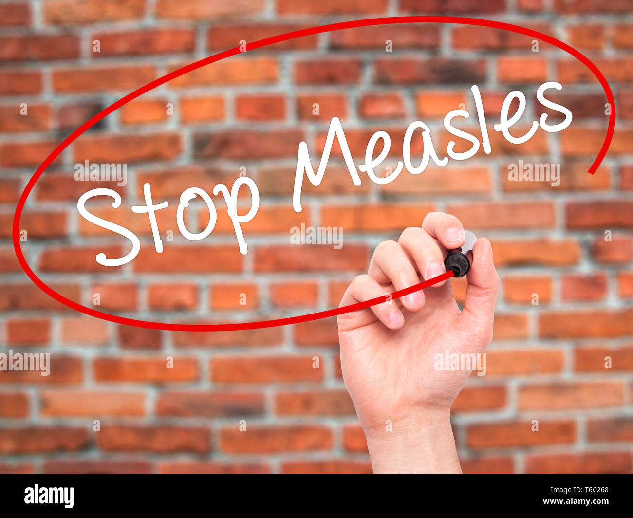 Man Hand writing Stop Measles  with black marker on visual screen Stock Photo