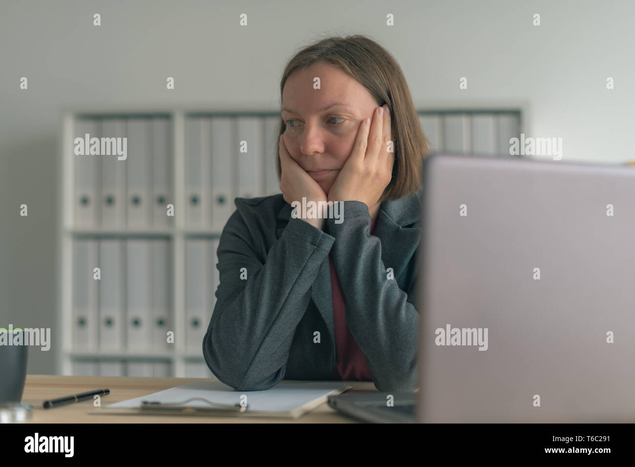 Disappointed businesswoman in office i let down by her coleagues and team Stock Photo