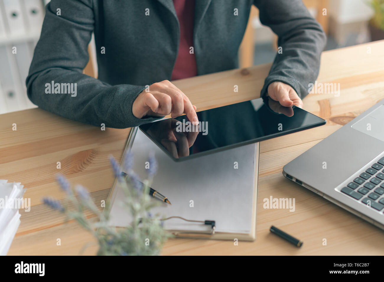 Businesswoman using tablet in office, modern contemporary technology gadgets in business operations Stock Photo