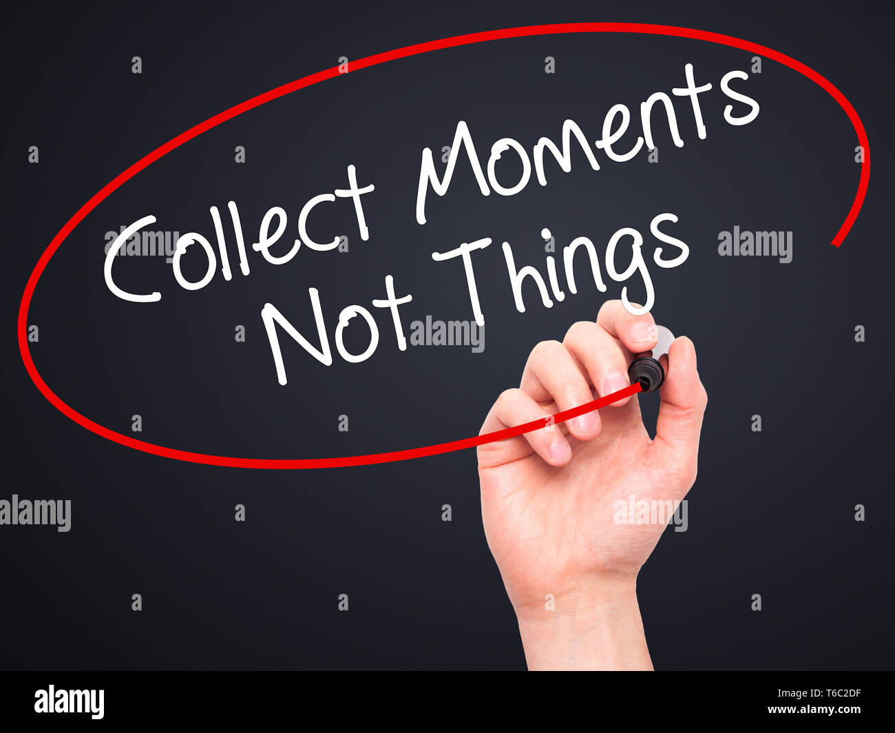 Man Hand writing Collect Moments Not Things with black marker on visual screen Stock Photo