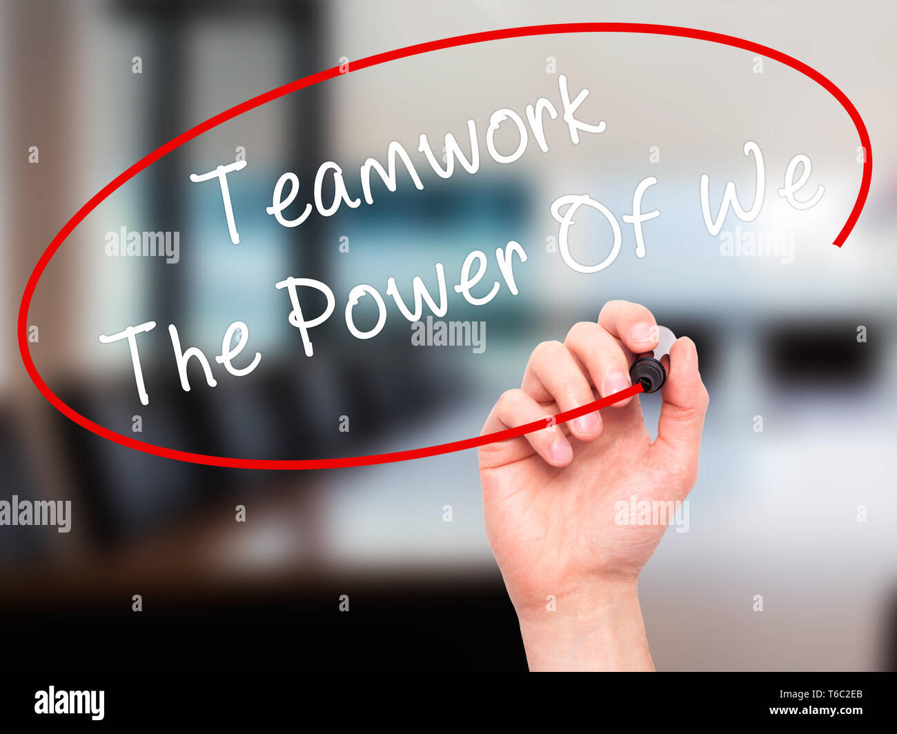 Man Hand writing Teamwork - The Power Of We with black marker on visual screen Stock Photo