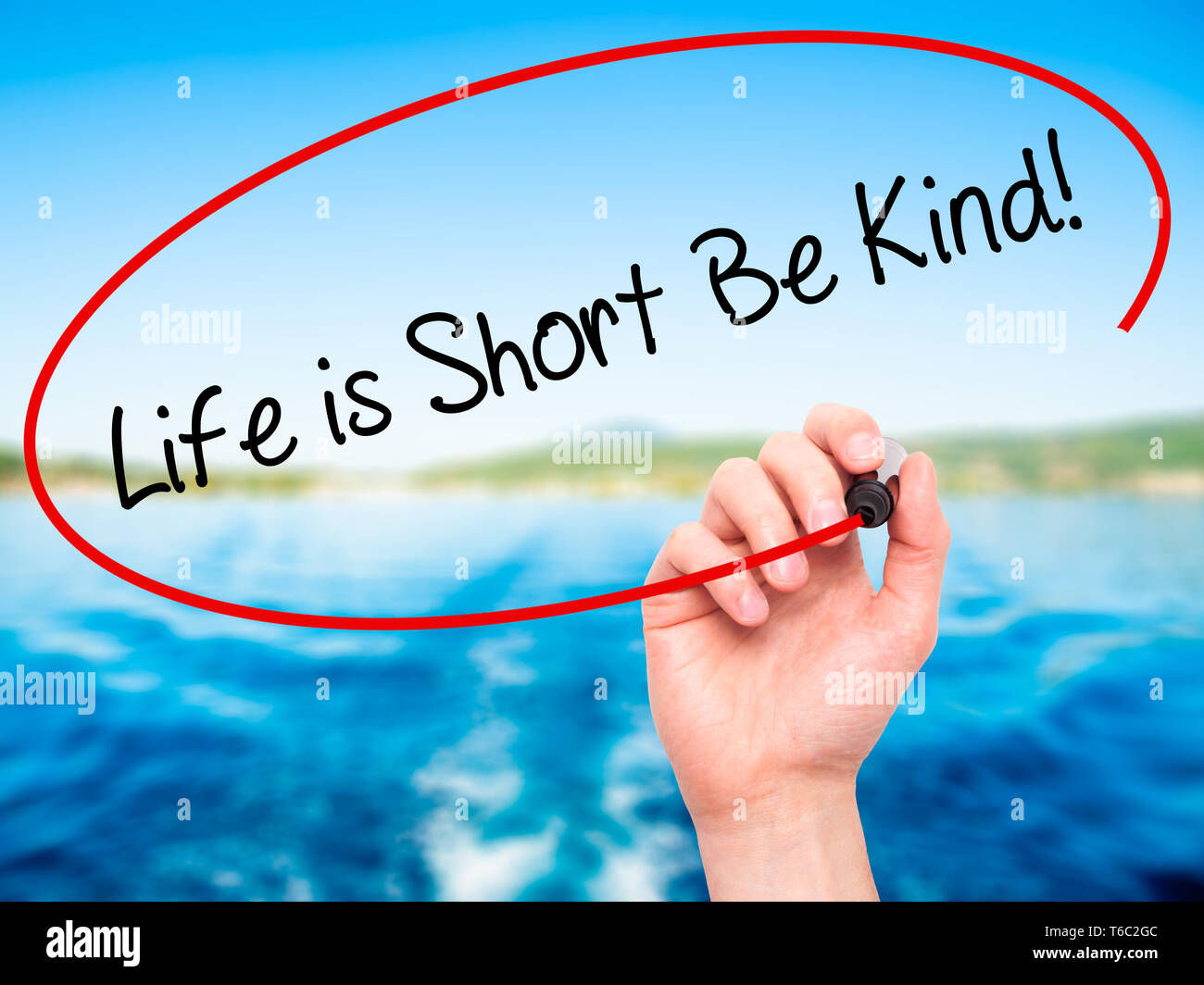 Man Hand writing Life is Short Be Kind! with black marker on visual screen Stock Photo
