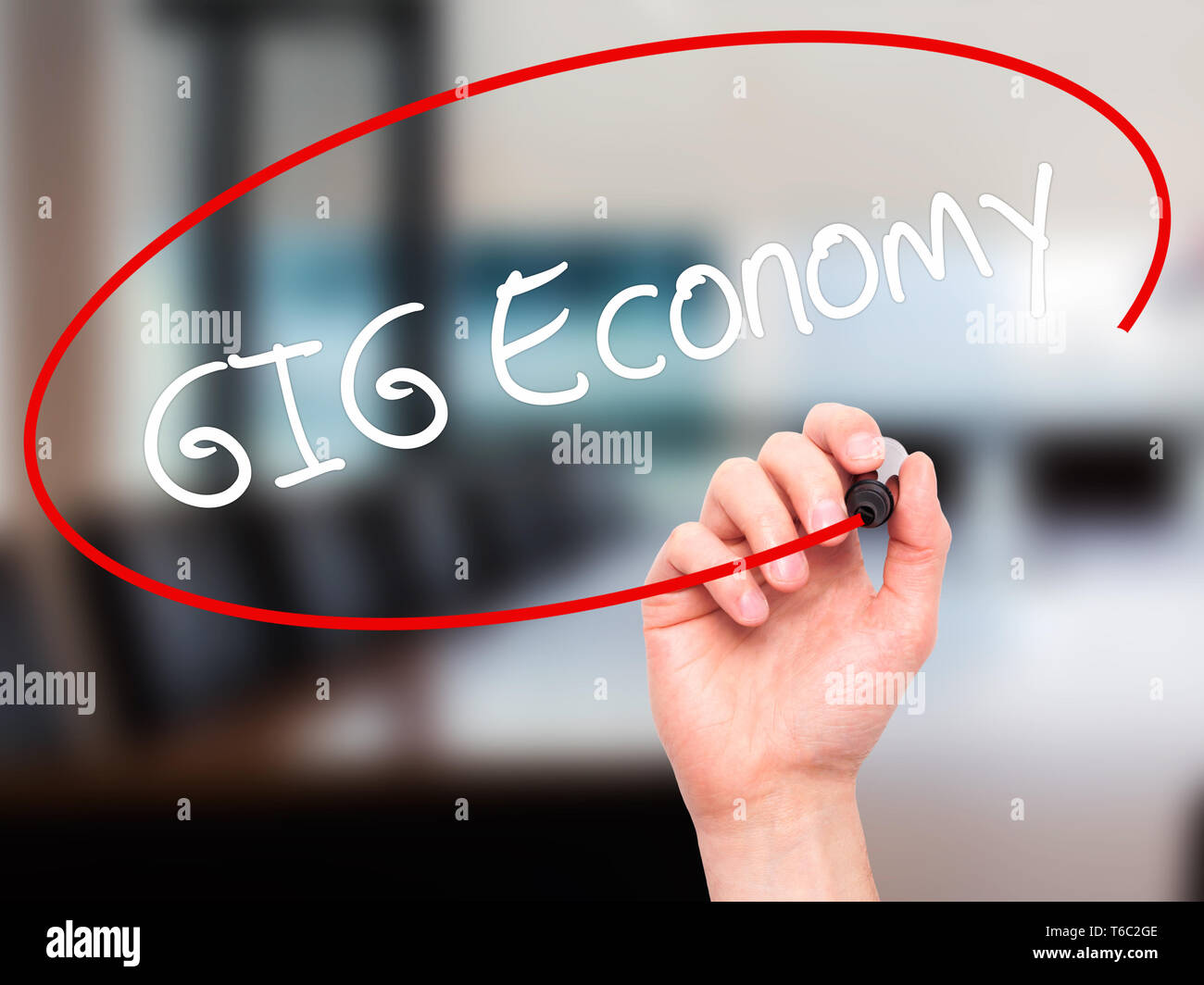 Man Hand writing GIG Economy with black marker on visual screen Stock Photo