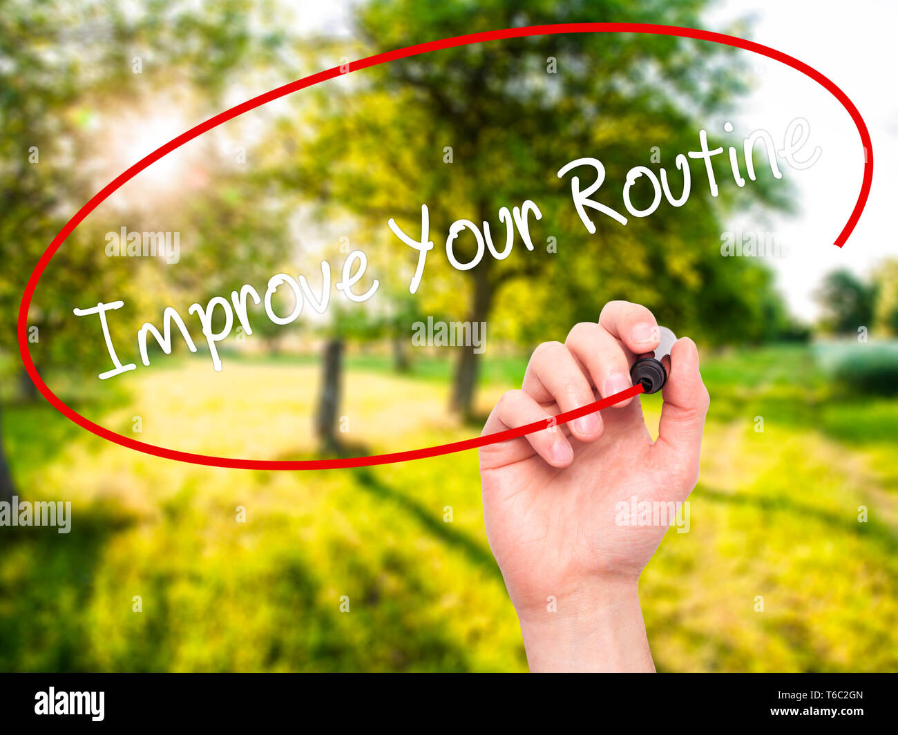 Man Hand writing Improve Your Routine with black marker on visual screen Stock Photo
