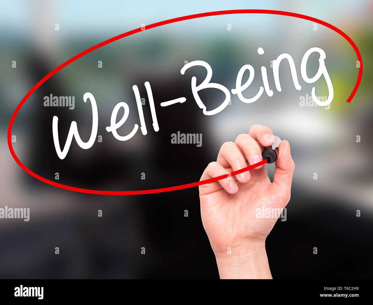 Man Hand writing Well-Being  with black marker on visual screen Stock Photo
