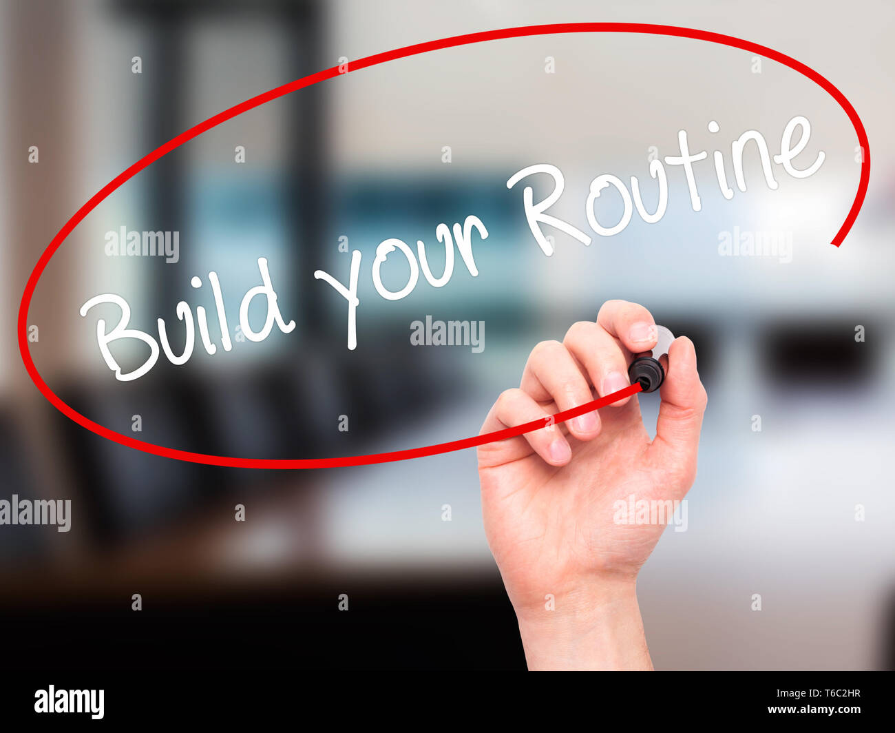 Man Hand writing Build your Routine with black marker on visual screen Stock Photo