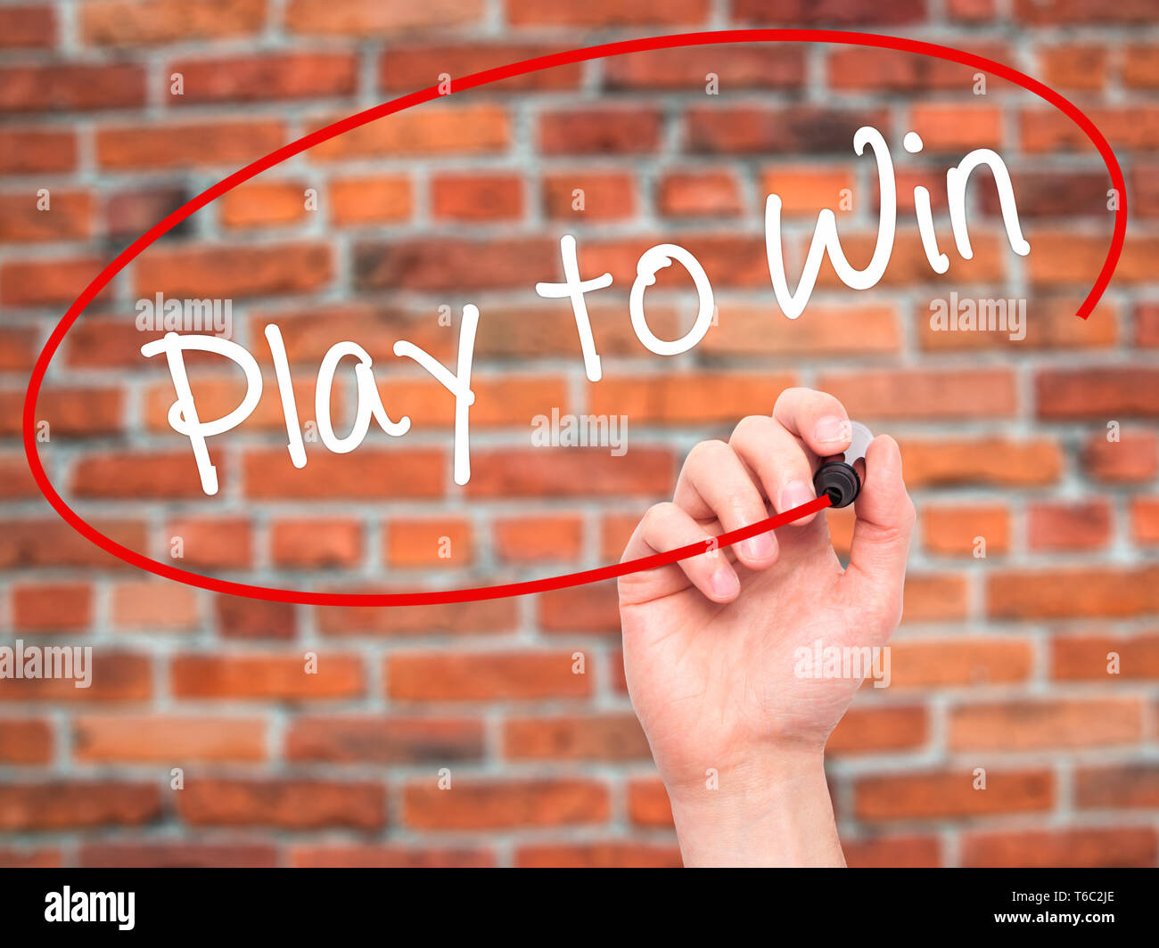 Man Hand writing Play to Win with black marker on visual screen Stock Photo