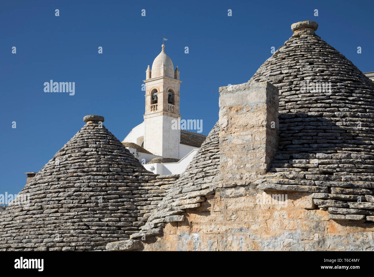 Italy, Apulia (Puglia), Bari district, Itria Valley, traditional trulli rooftops and church at Alberobello Stock Photo