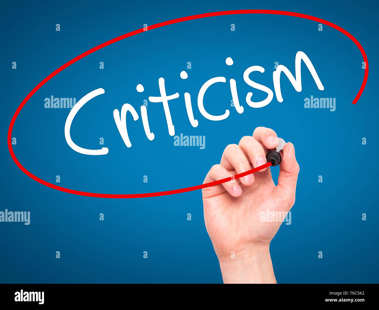 Man Hand writing Criticism with black marker on visual screen Stock Photo
