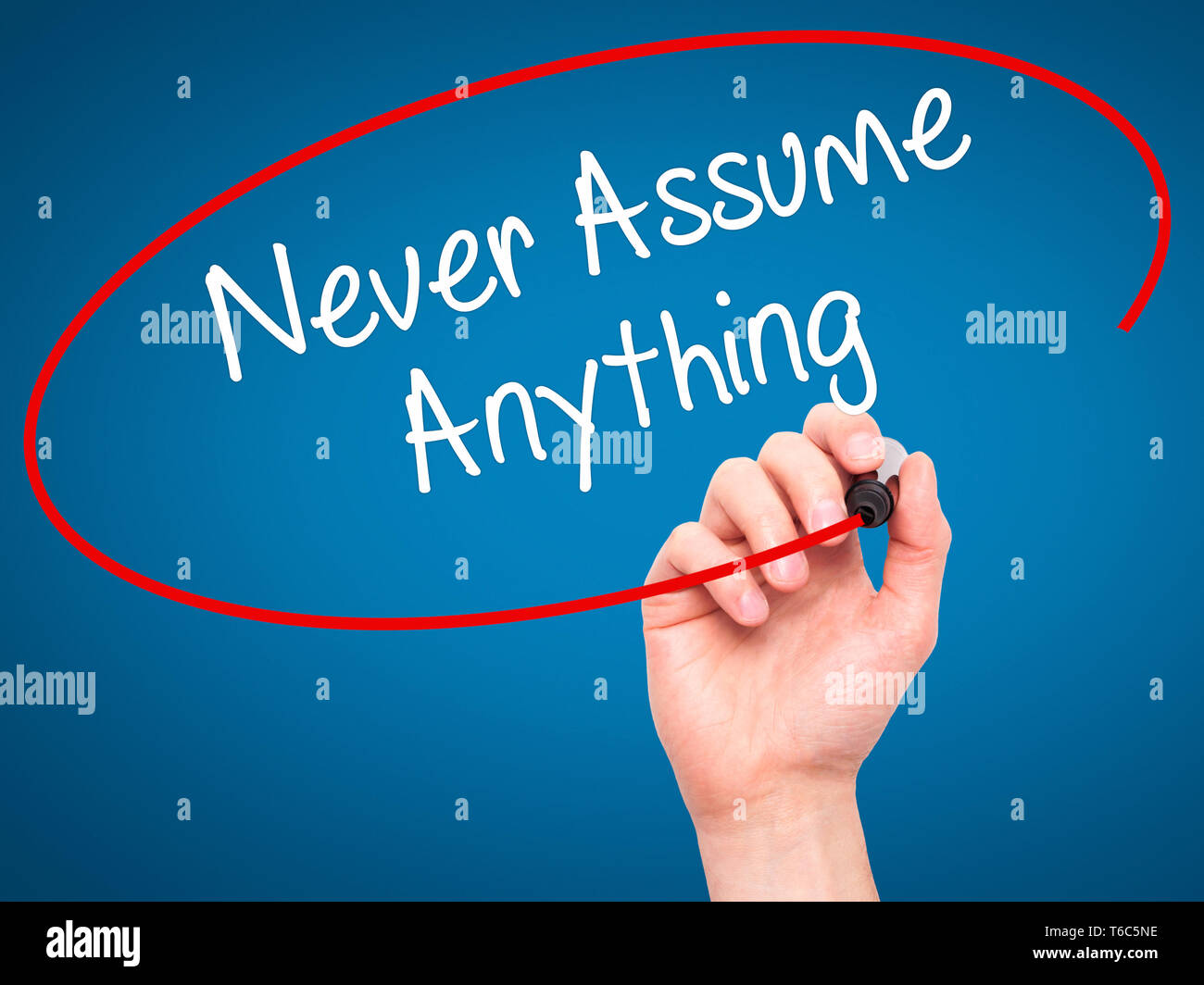 Man Hand writing Never Assume Anything with black marker on visual screen Stock Photo