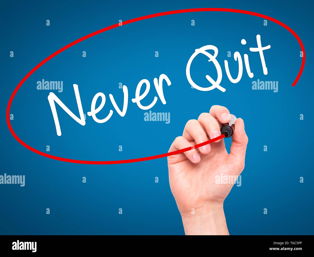 Man Hand writing Never Quit with black marker on visual screen. Stock Photo