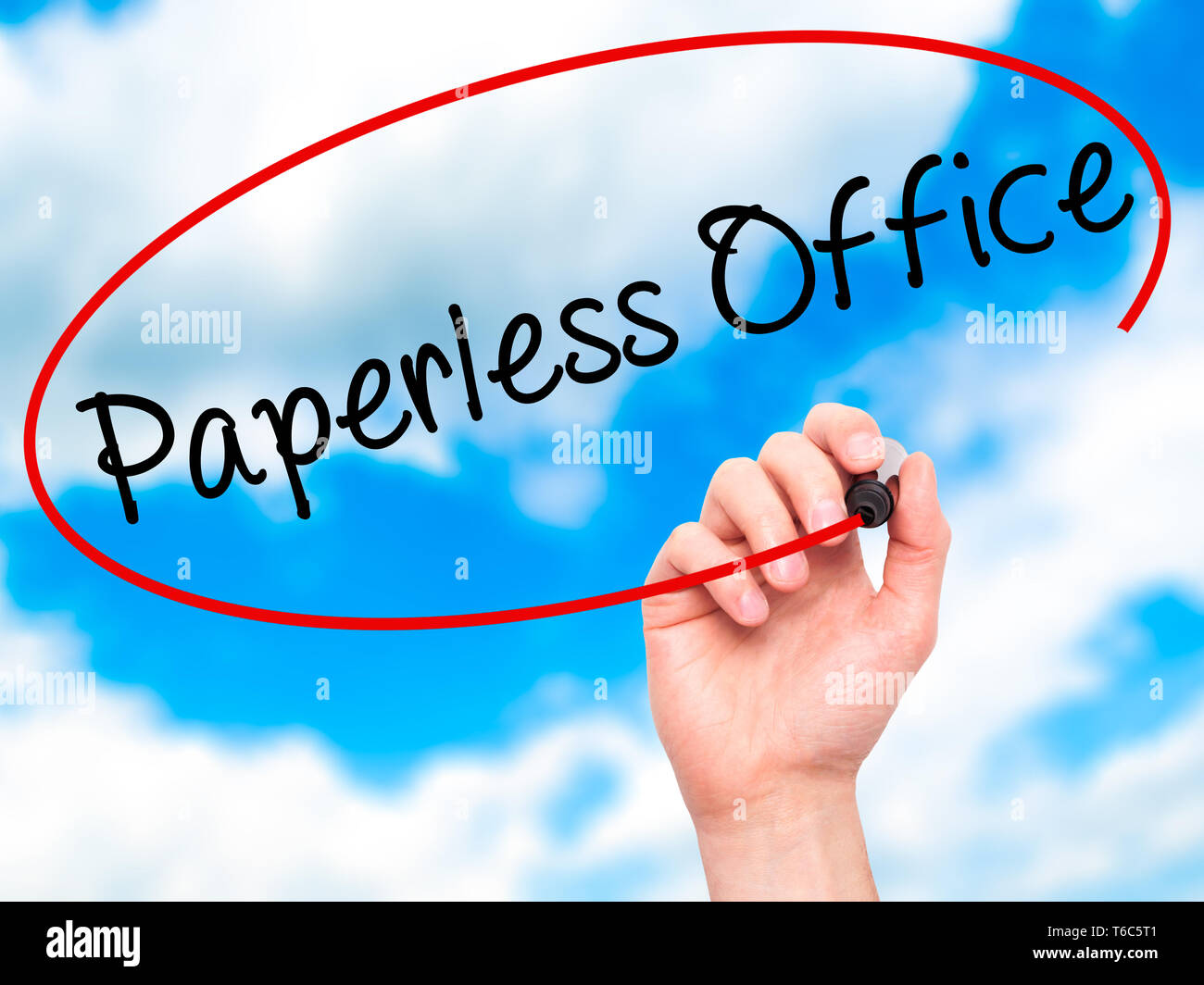 Man Hand writing Paperless Office  with black marker on visual screen Stock Photo