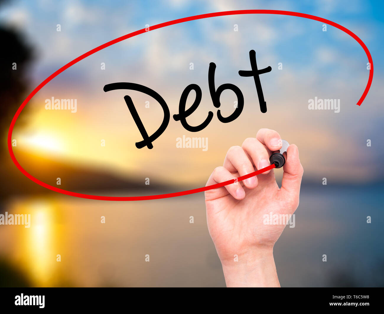 Man Hand writing Debt with black marker on visual screen Stock Photo