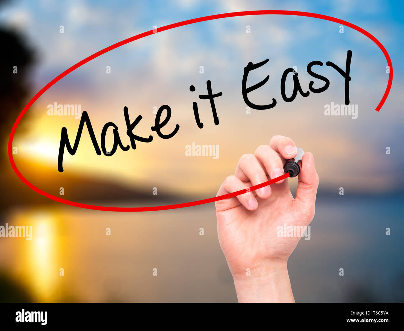 Man Hand writing Make it Easy with black marker on visual screen Stock Photo