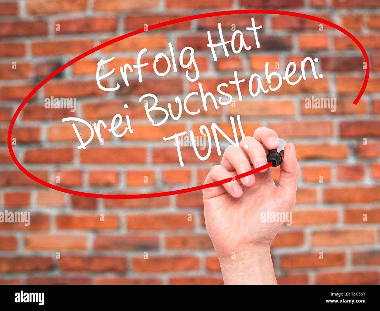 Man Hand writing Erfolg Hat Drei Buchstaben: Tun! (Success Has Three Letters: Do in German) with black marker on visual screen Stock Photo