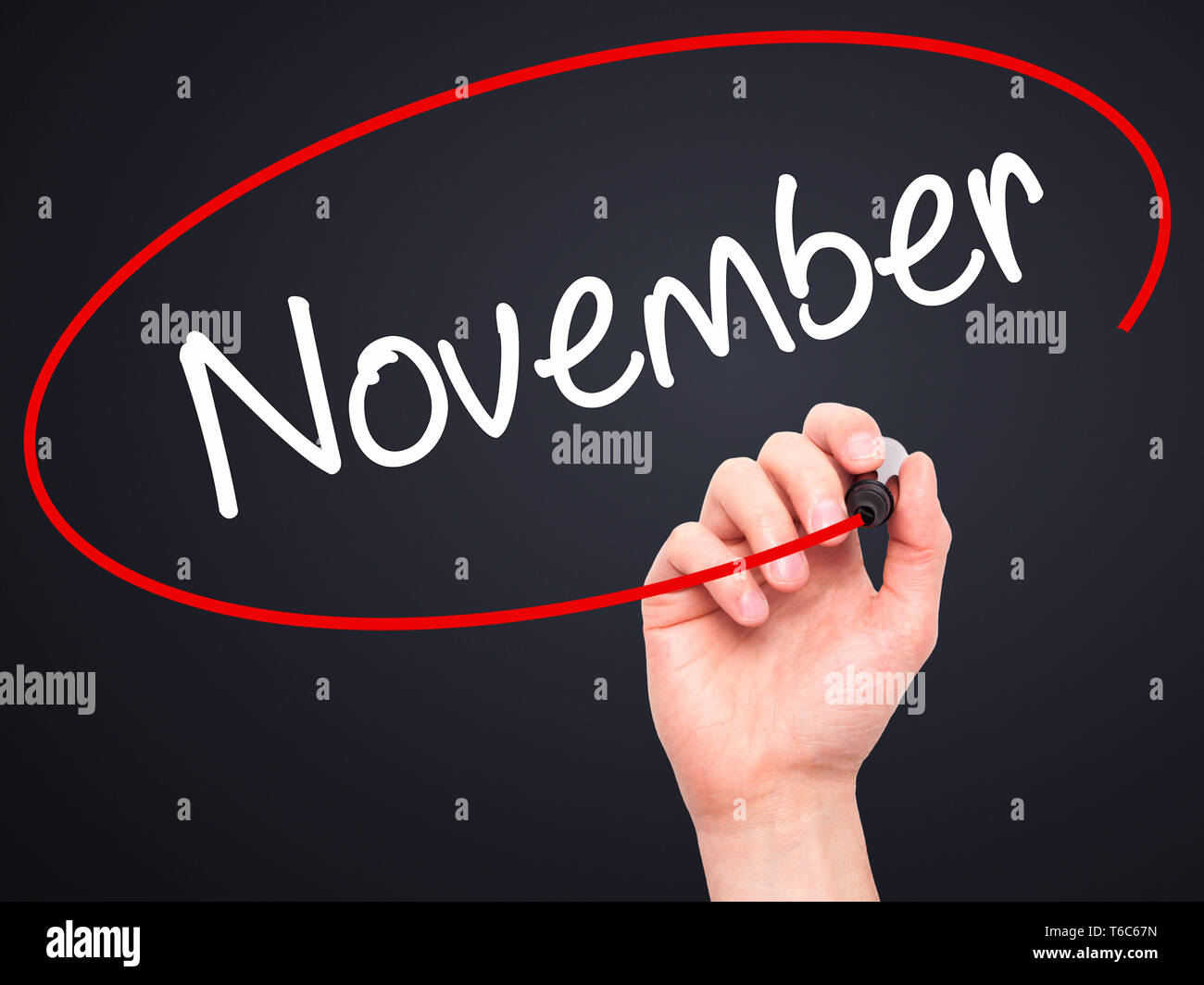 Man Hand writing November with black marker on visual screen Stock Photo