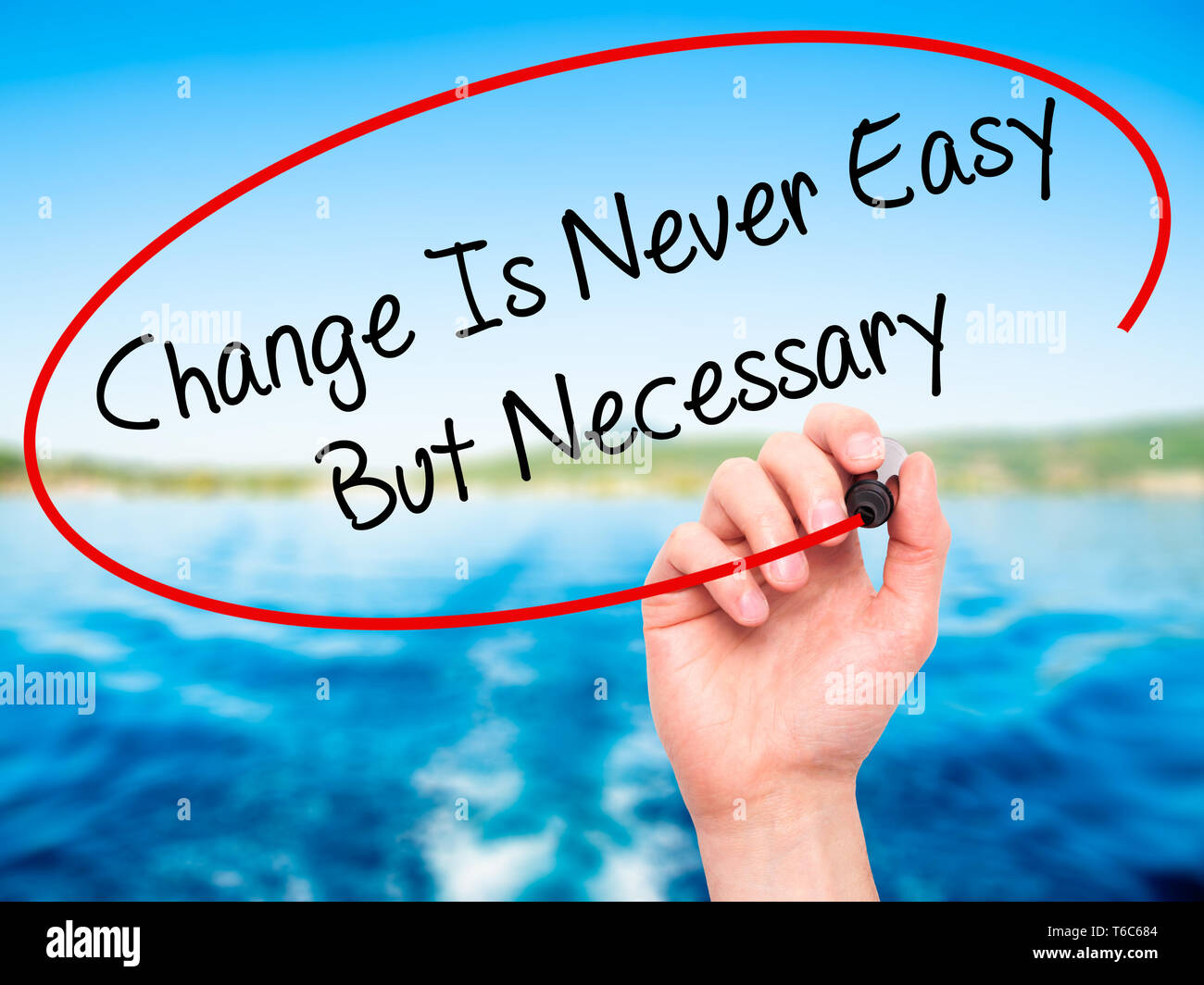 Man Hand writing Change Is Never Easy But Necessary with black marker on visual screen Stock Photo