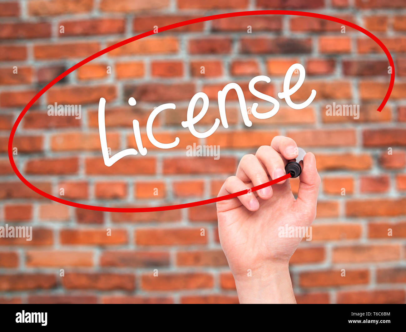 Man Hand writing License with black marker on visual screen Stock Photo
