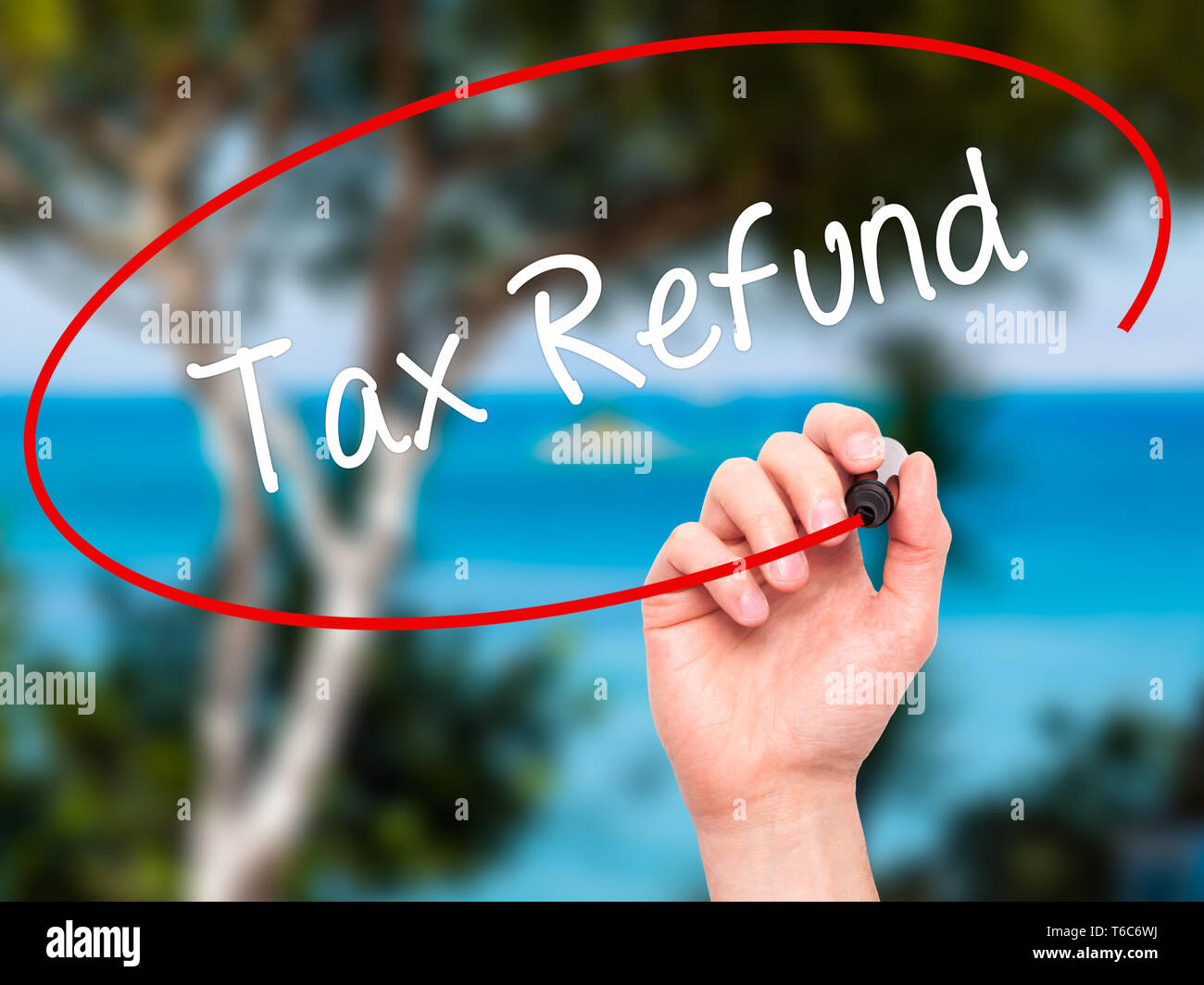 Man Hand writing Tax Refund with black marker on visual screen Stock Photo