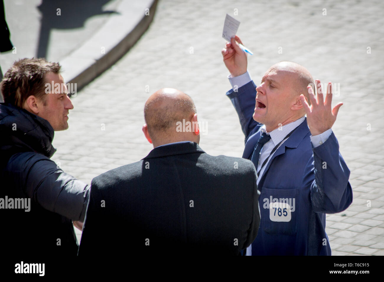 A floor trader gestures while talking to two other men outside the NYSE Euronext Stock Exchange on Wall Street. Stock Photo