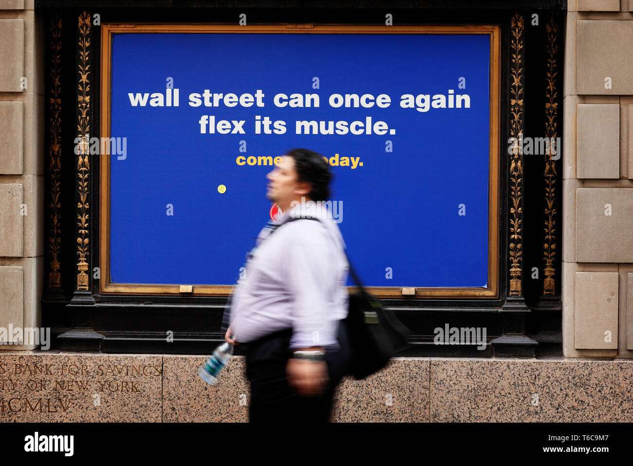An ad on Wall Street for New York Sports Club states ' Wall Street can once again flex it's muscles. ' Stocks on Wall Street surge in the morning, reacting to the 117k jobs added in the last week. Stock Photo