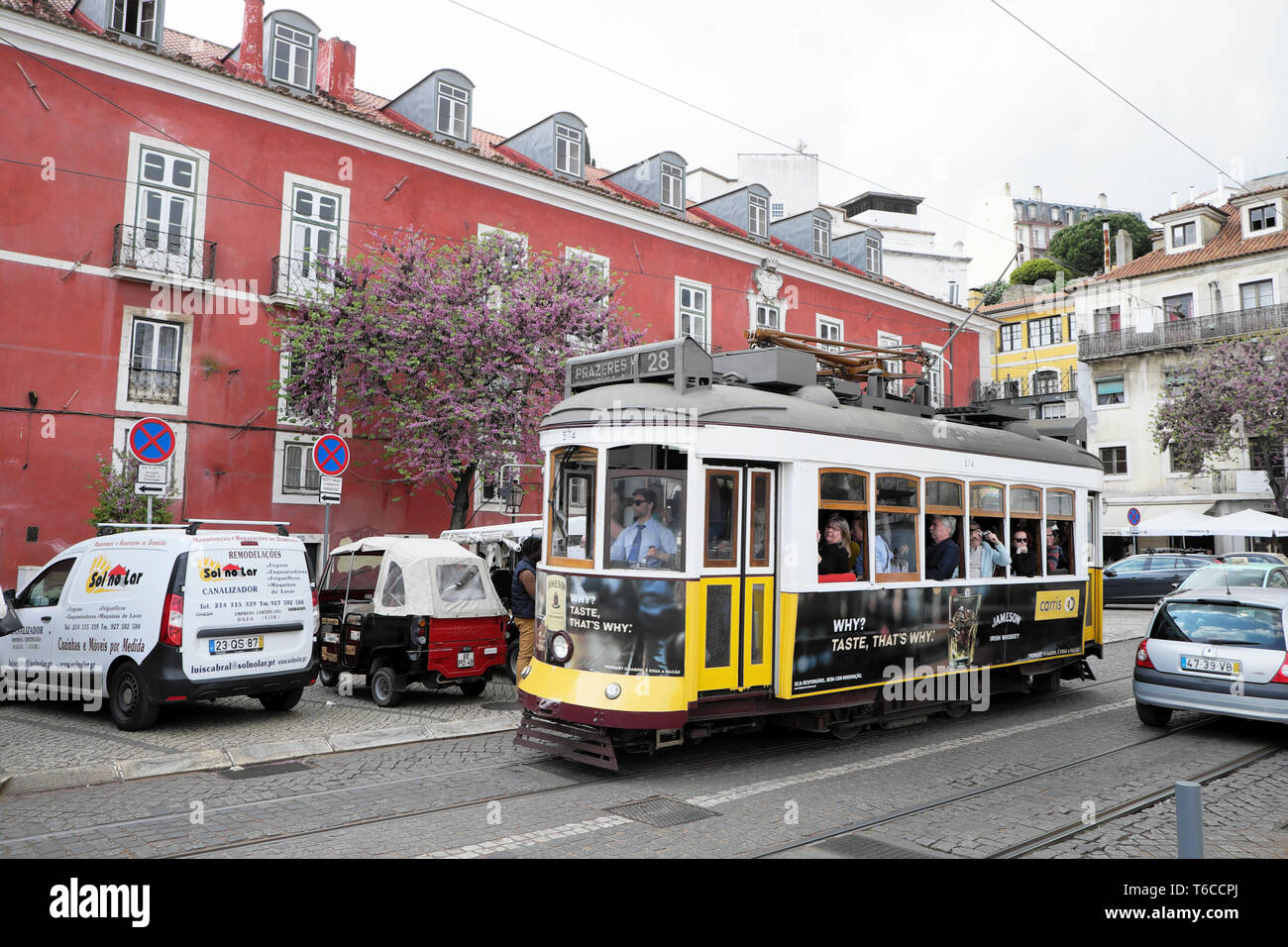 Tourists looking out the window of a Lisbon tram 28 in spring in the Alfama district of Lisbon Portugal Europe EU  KATHY DEWITT Stock Photo