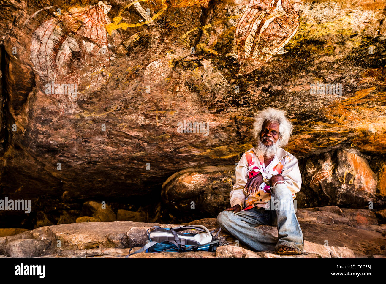 Native Guide explaining Aborigine Rock Art in Long Tom Dreaming, Gunbalanya, Australia Stock Photo
