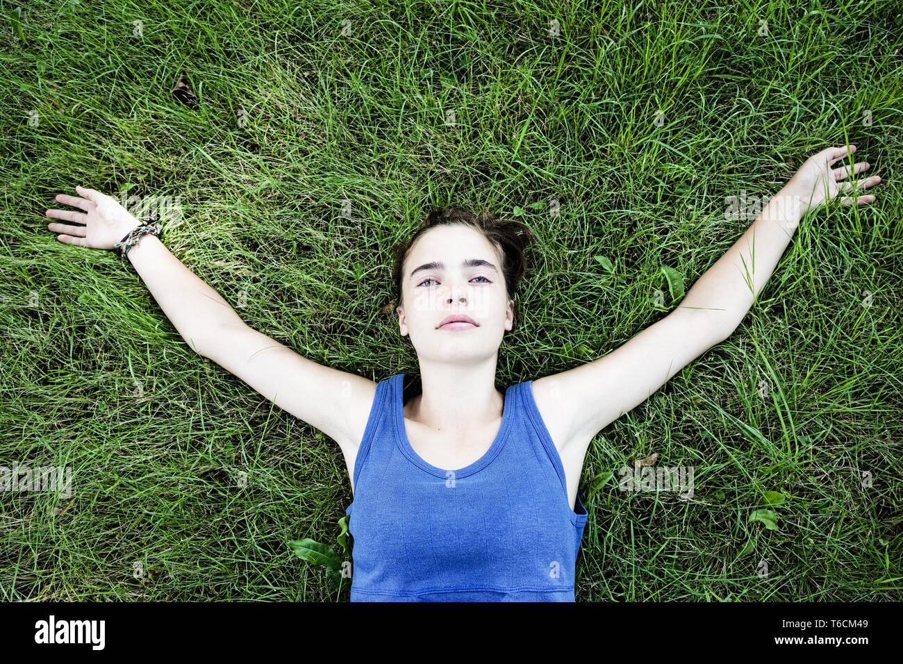 portrait of a young woman lying on a meadow Stock Photo