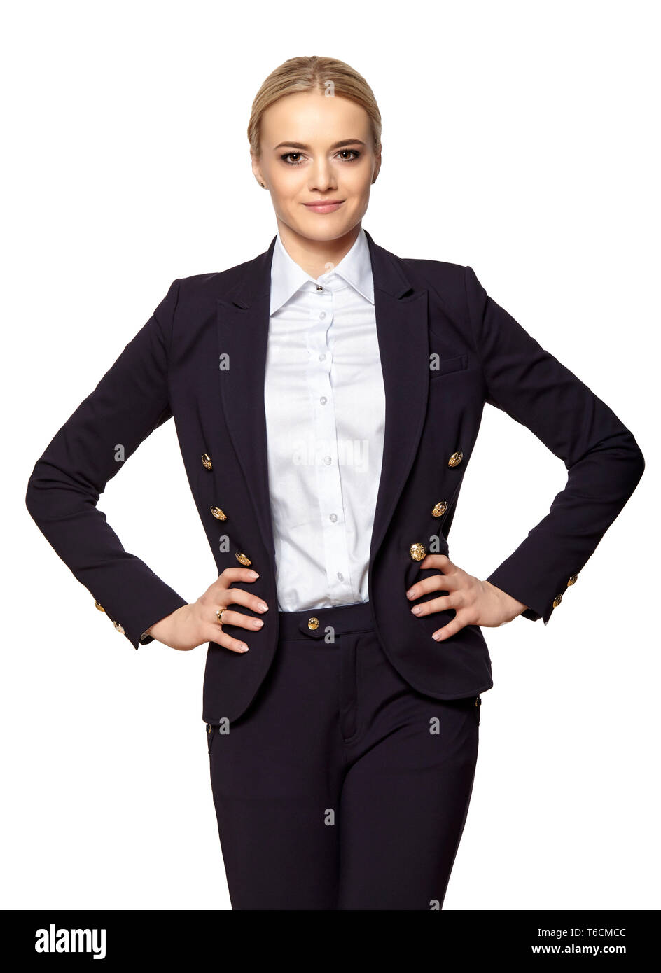 Studio portrait of a confident blonde businesswoman stands with hands on hips. Stock Photo