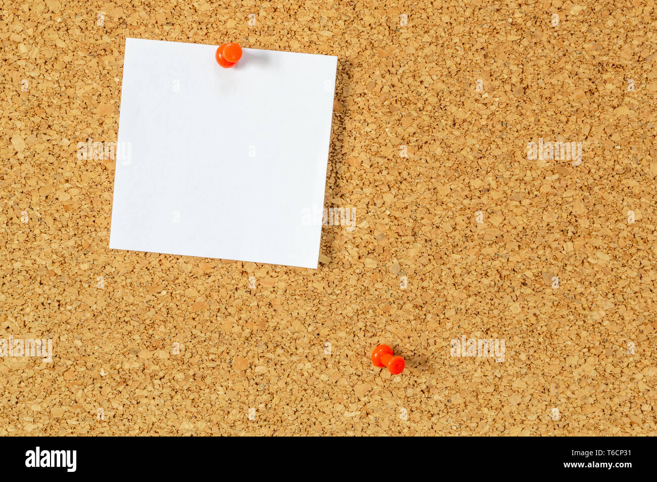 Cork board with pinned blank notepaper. Stock Photo