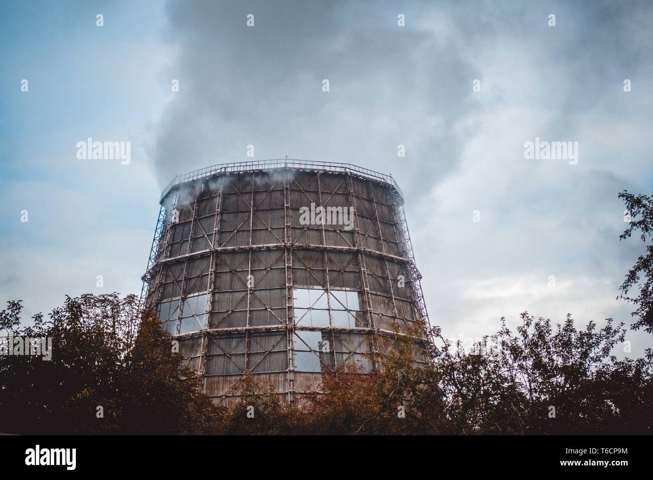 big old cooling pipe with steam, smoke in cloudy weather in autumn Stock Photo