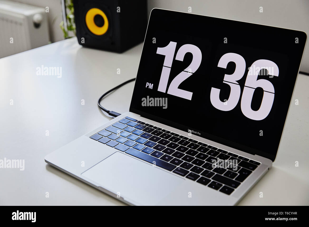 Apple MacBook Pro notebook with the clock screensaver on the big white Ikea  desk office with the black yellow speakers, iPhone in the background Stock  Photo - Alamy